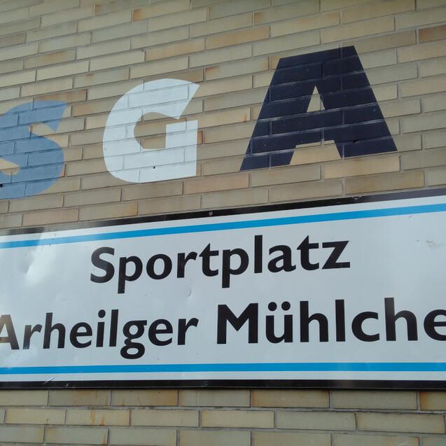 Wand mit dem Schriftzug &bdquo;SGA&ldquo; und einem Schild, das &bdquo;Sportplatz Arheilger M&uuml;hlchen&ldquo; anzeigt.