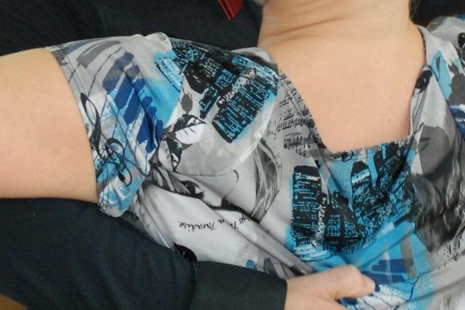 Tanzende Personen in eleganter Kleidung umarmen sich in einem Saal mit Holzfu&szlig;boden.